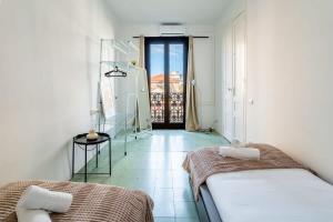 um quarto com duas camas e uma porta para uma varanda em Historic Catalan 4BD apartment in Gran Vía em Barcelona