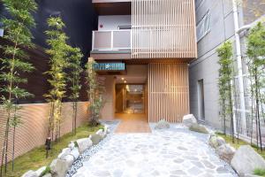 einen Außenblick auf ein Gebäude mit Bäumen und einem Gehweg in der Unterkunft Hotel Fu-Rin in Fukuoka