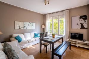 a living room with a white couch and a table at Sants Estacio - Modern and comfy 4BD for 8 guests in Barcelona