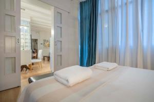 1 Schlafzimmer mit einem weißen Bett und einem Esszimmer in der Unterkunft Exclusive 2 bedroom apartment in the city center in Barcelona