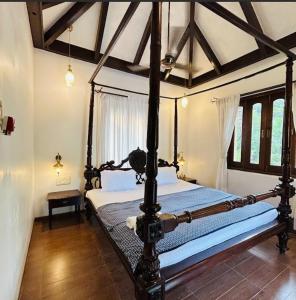 ein Schlafzimmer mit einem Himmelbett in einem Zimmer in der Unterkunft Opal Oasis Villa in Alībāg