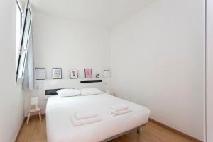 a white bedroom with a white bed with white sheets at 3BD in Poblenou next to the beach in Barcelona