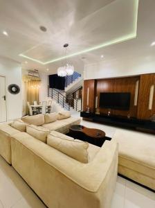 a living room with a large couch and a television at Where Luxury Meets Comfort in Lagos