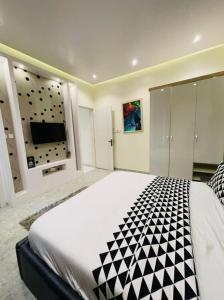 a large bedroom with a large bed and a flat screen tv at Where Luxury Meets Comfort in Lagos