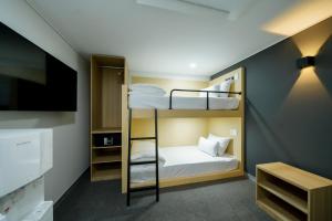 a room with two bunk beds and a flat screen tv at The Stay Hue Myeongdong in Seoul