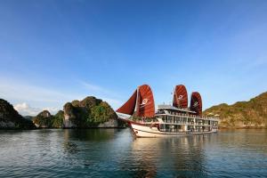 un crucero en el agua cerca de algunas montañas en V'Spirit Cruise en Ha Long