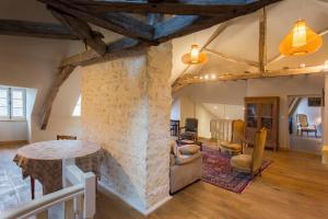 a living room with a stone pillar and a table at La Maison du Haut in Tonnerre