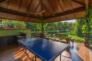 a ping pong table in the middle of a patio at StayVista at Moksh Villa - BBQ & Jacuzzi in Alibaug