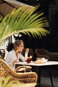 a woman sitting at a table eating food at Reservoir Hotels in Siem Reap