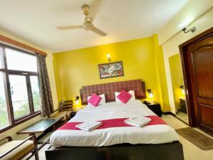 um quarto com uma cama grande e almofadas cor-de-rosa em Hotel Surya Beach inn ! PURI near-sea-beach-and-temple fully-air-conditioned-hotel with-lift-and-parking-facility em Puri