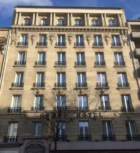 duży budynek z balkonami po jego stronie w obiekcie Les Appartements du Grand Hôtel Clichy Paris w mieście Clichy