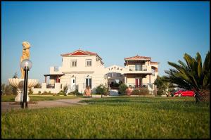 a large white house with a statue in front of it at ilyda Residence apts in Skala Kallonis