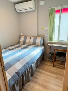 a bed in a small room with a window at SHINJUKU WARM HOUSE in Tokyo
