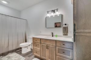 W łazience znajduje się umywalka, toaleta i lustro. w obiekcie "4br Northwood Lake Getaway Relax Or Adventure! w mieście Birchwood