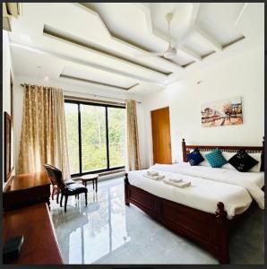 a bedroom with a large bed and a desk and chair at Paige's Villa in Alibag