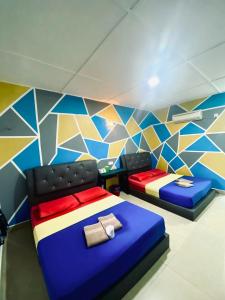 two beds in a room with a colorful wall at Abot guest house in Kuala Tahan