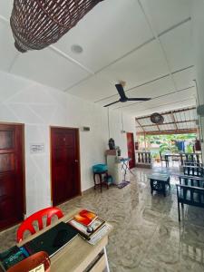 ein Wohnzimmer mit einem Tisch, Stühlen und einer Decke in der Unterkunft Abot guest house in Kuala Tahan