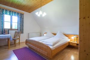 een slaapkamer met een bed, een tafel en een raam bij PEISERHOF ferien.wein.gut Südsteiermark in Wies