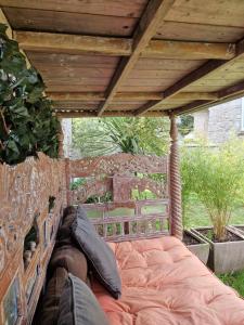 a bed under a wooden roof with pillows on it at Villa Fresquet in Cherbourg en Cotentin