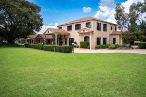 uma casa grande com um relvado em frente em Best Western Tuscany on Tor Motor Inn em Toowoomba