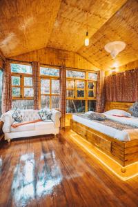 2 łóżka w pokoju z drewnianymi podłogami i oknami w obiekcie Banana Farm Eco Hostel w mieście Arusza