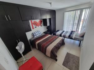 a small bedroom with a bed and a fan at Casa con alberca Lomas de San Pedro SD in Querétaro