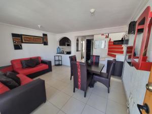 a living room with a red couch and a table at Casa con alberca Lomas de San Pedro SD in Querétaro