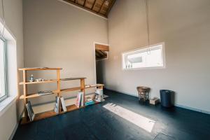 Habitación con estanterías de madera y ventana en 宿と古道具 iyooo, en Nanao