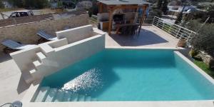 - une vue sur la piscine d'eau bleue dans l'établissement Rafaela holiday home, à Pitsidia