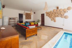 a living room with a couch and a swimming pool at Bukoba Villas - Lily - Private Pool, AC & Wi-Fi in Nungwi