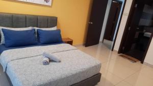 ein Schlafzimmer mit einem Bett mit blauen Kissen in der Unterkunft KSL Suites in Johor Bahru