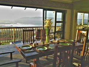 a dining room table with a view of the ocean at Knysnaviews Guest House in Knysna