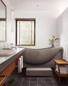 ein Badezimmer mit einer großen Badewanne und einem Waschbecken in der Unterkunft Hillocks Hotel & Spa in Siem Reap