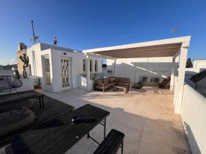 un patio con una mesa de madera y un pabellón en Apartamentos Caravane, en Tarifa