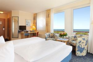 una camera d'albergo con un grande letto e sedie di Morada Resort Kühlungsborn a Kühlungsborn Altre 27 foto