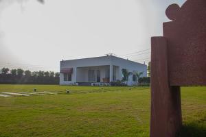 a large white building in the middle of a field at The Peace- A Luxury Pool Villa in Jaipur