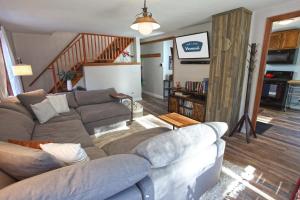 sala de estar con sofá y escalera en Dream Stratton Forest Cabin with Hot Tub and Fast WiFi, en Stratton