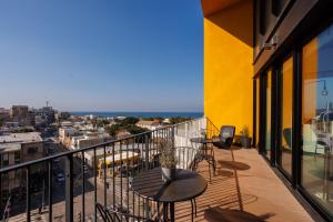 a balcony with tables and chairs and a view of the city at Elifelet Boutique By Nimizz in Tel Aviv