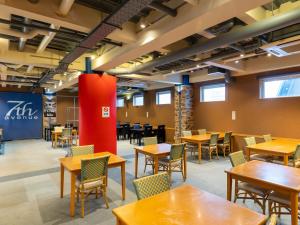 an empty dining room with tables and chairs at Tabist Hirosaki Touei Hotel in Hirosaki