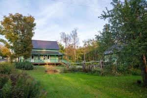 una casa verde con una valla en un patio en Adventurer's Home by Kingdom Trails and Burke Mtn en East Burke
