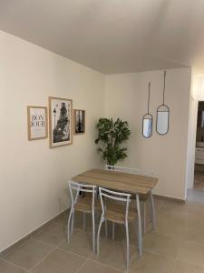 ein Esszimmer mit einem Holztisch und Stühlen in der Unterkunft Coliving - chambre jaune in Sarcelles