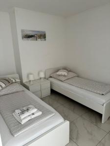 two beds in a room with white walls at Sahara Falcon in Munich