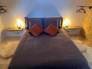 uma cama grande num quarto com duas lâmpadas em Le perchoir nocturne em Payré-sur-Vendée