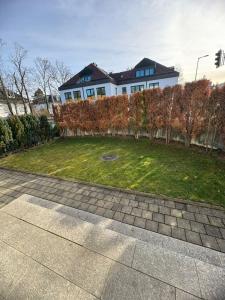 a white house with a fence and a yard at Sahara Falcon in Munich