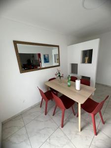 Sahara Falcon في ميونخ: طاولة غرفة الطعام مع كراسي حمراء ومرآة