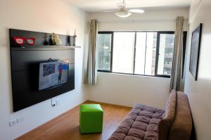sala de estar con sofá y TV de pantalla plana en Apartamento Beira Mar Maceió ll, en Maceió