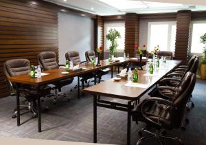 uma sala de conferências com mesas longas e cadeiras em Swiss International Al Hamra Hotel em Dammam