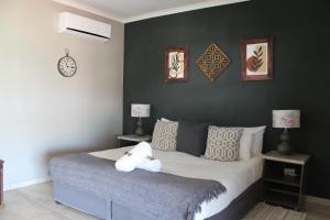 un dormitorio con una cama con un animal de peluche en Ley-Lia Guest House, en Aranos