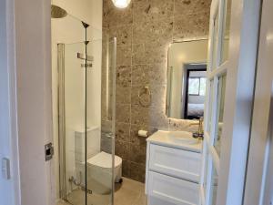 a bathroom with a shower and a sink and a mirror at Redgate Homestead in Hartley