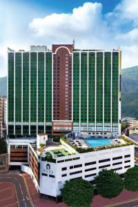 香港的住宿－悅來酒店，一座大型建筑,前面设有一个游泳池